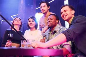 emozioni positive. gruppo di amici che si divertono insieme nel night club foto