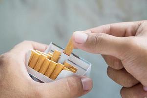 staccalo dal pacchetto di sigarette fumando una sigaretta. foto filtra la luce naturale.