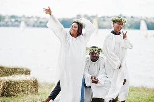 tre amici afroamericani su mantelli bianchi e corona che si divertono insieme. foto