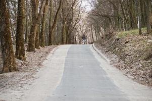 uomo arabo in stile street con occhiali da vista con longboard longboard lungo la strada. foto