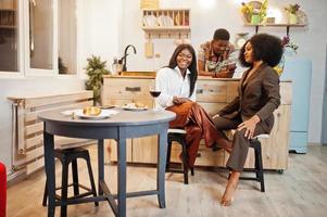 tre amici afroamericani che trascorrono del tempo in cucina con il vino. i neri si rilassano a casa. foto