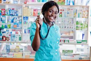 farmacista afroamericano che lavora in farmacia presso la farmacia dell'ospedale. assistenza sanitaria africana. stetoscopio sul medico donna nera. foto