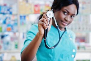 farmacista afroamericano che lavora in farmacia presso la farmacia dell'ospedale. assistenza sanitaria africana. stetoscopio sul medico donna nera. foto
