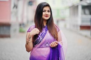 ragazza indù indiana al tradizionale saree viola poste in strada. foto