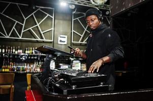 dj afroamericano suona musica sui ponti del night club. foto