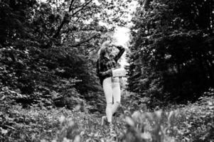 ritratto di una giovane e bella donna bionda in camicia scozzese in possesso di una mappa nella foresta. foto