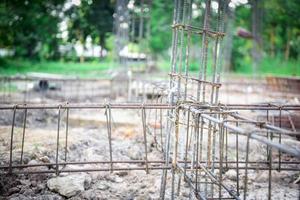 primo piano che fabbrica una barra di rinforzo in acciaio nel cantiere per la costruzione della casa foto