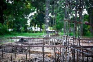 primo piano che fabbrica una barra di rinforzo in acciaio nel cantiere per la costruzione della casa foto