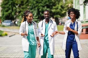 tre medici di gruppo afroamericani con uno stetoscopio che indossano un camice da laboratorio. foto