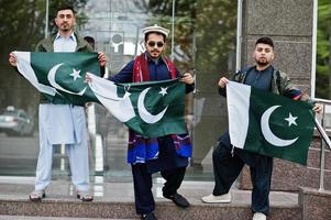 gruppo di pakistani che indossano abiti tradizionali salwar kameez o kurta con bandiere pakistane. foto