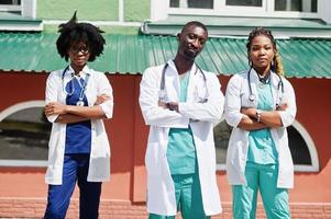 tre medici di gruppo afroamericani con uno stetoscopio che indossano un camice da laboratorio. foto