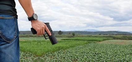 Pistola automatica da 9 mm che tiene nella mano destra del tiratore, concetto di sicurezza, rapina, gangster, guardia del corpo in tutto il mondo. messa a fuoco selettiva sulla pistola. foto