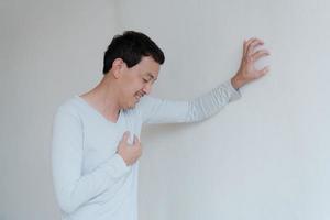 un uomo che tocca il suo cuore, con evidenziazione rossa di infarto e altri concetto di malattia cardiaca, sintomo di infarto foto