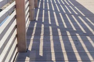 ombre della ringhiera sul ponte di legno per lo sfondo. foto