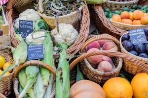 un assortimento di frutta e verdura matura in cesti al mercato contadino foto