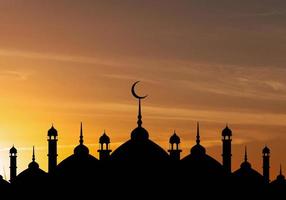 cupola delle moschee sul cielo crepuscolare blu scuro e luna crescente sullo sfondo, simbolo religione islamica ramadan e spazio libero per il testo arabo, eid al-adha, eid al-fitr, mubarak, capodanno islamico muharram foto