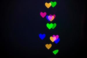 cuore bokeh sfondo, amore e concetto di San Valentino. luce di cuori lucidi multicolori foto