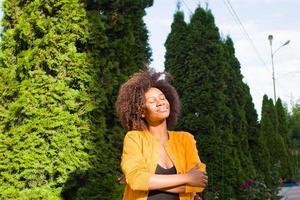 una felice e giovane donna afroamericana cammina per strada foto