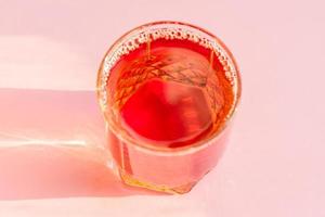 bicchiere di succo di mela su sfondo rosa. bevanda analcolica. foto