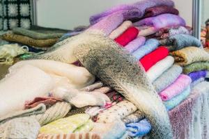 pila di sciarpe lanuginose lavorate a maglia per lo sfondo. scialli famosi russi di Orenburg. uncinetto, modello. foto