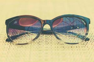occhiali da sole alla moda su un tavolo. concetto estivo. stile di colore vintage foto