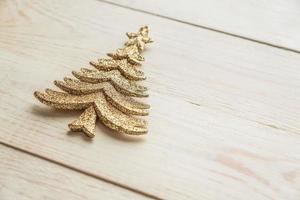 giocattolo decorativo dell'albero di natale dell'oro su fondo di legno. concetto festivo di inverno di capodanno foto