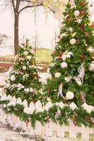 decorazione di strada di natale. alberi di pelliccia con palline e ghirlande foto