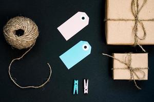 scatole regalo artigianali avvolte in carta artigianale con cartellino in carta blu, corda e mollette in legno per la decorazione. foto