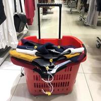 carrello della spesa in plastica rossa pazzo di abbigliamento femminile in negozio foto