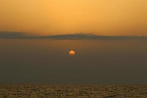 il sole tramonta sotto l'orizzonte sul Mar Mediterraneo nel nord di Israele. foto