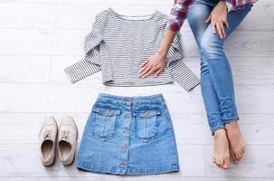 vestito di moda con parti del corpo femminile su fondo di legno bianco. vista dall'alto e spazio di copia. foto