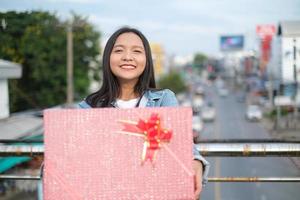 contento giovane ragazza con regalo scatola. foto