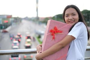 contento giovane ragazza con regalo scatola. foto