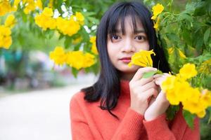 ritratto giovane ragazza con fiori gialli, ragazza asiatica. foto