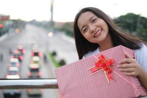 contento giovane ragazza con regalo scatola. foto