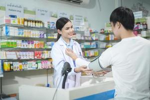 donna farmacista consulenza cliente sull'uso di droghe in una moderna farmacia farmacia. foto