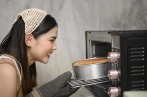 la giovane bella donna sta cuocendo nella sua attività di cucina, panetteria e caffetteria foto