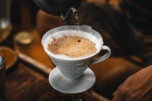 il primo piano delle mani il barista fa il caffè foto