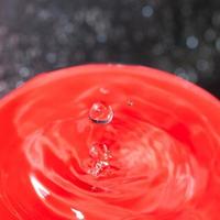 acqua far cadere su rosso sfondo vicino su foto