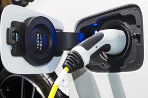 la ricarica della batteria per l'auto nuove innovazioni automobilistiche l'alimentatore collegato a un'auto elettrica in carica, concetto di innovazione energetica. foto