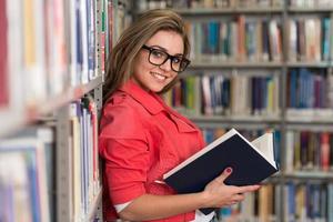 Ritratto di una ragazza studentessa che studia in biblioteca foto