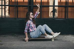 moda donna seduta su skateboard foto