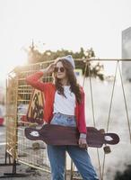 attraente donna con un' skateboard nel città foto