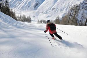 sciare sulla neve fresca nella stagione invernale in una bella giornata di sole foto