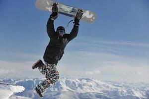 lo snowboarder freestyle salta e cavalca foto