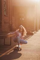 adolescente ragazza seduta su skateboard foto
