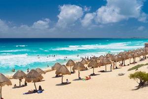 ombrelloni su una spiaggia sabbiosa con acqua azzurra in una giornata di sole vicino a cancun, in messico foto