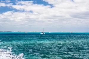 barca a vela e turchese chiaro acqua, blu acqua, caraibico oceano, isla mujeres, Cancun, Yucatan, Messico foto