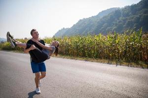 coppia felice jogging lungo una strada di campagna foto