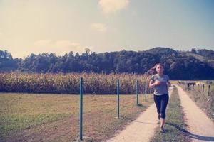 donna che fa jogging lungo una strada di campagna foto